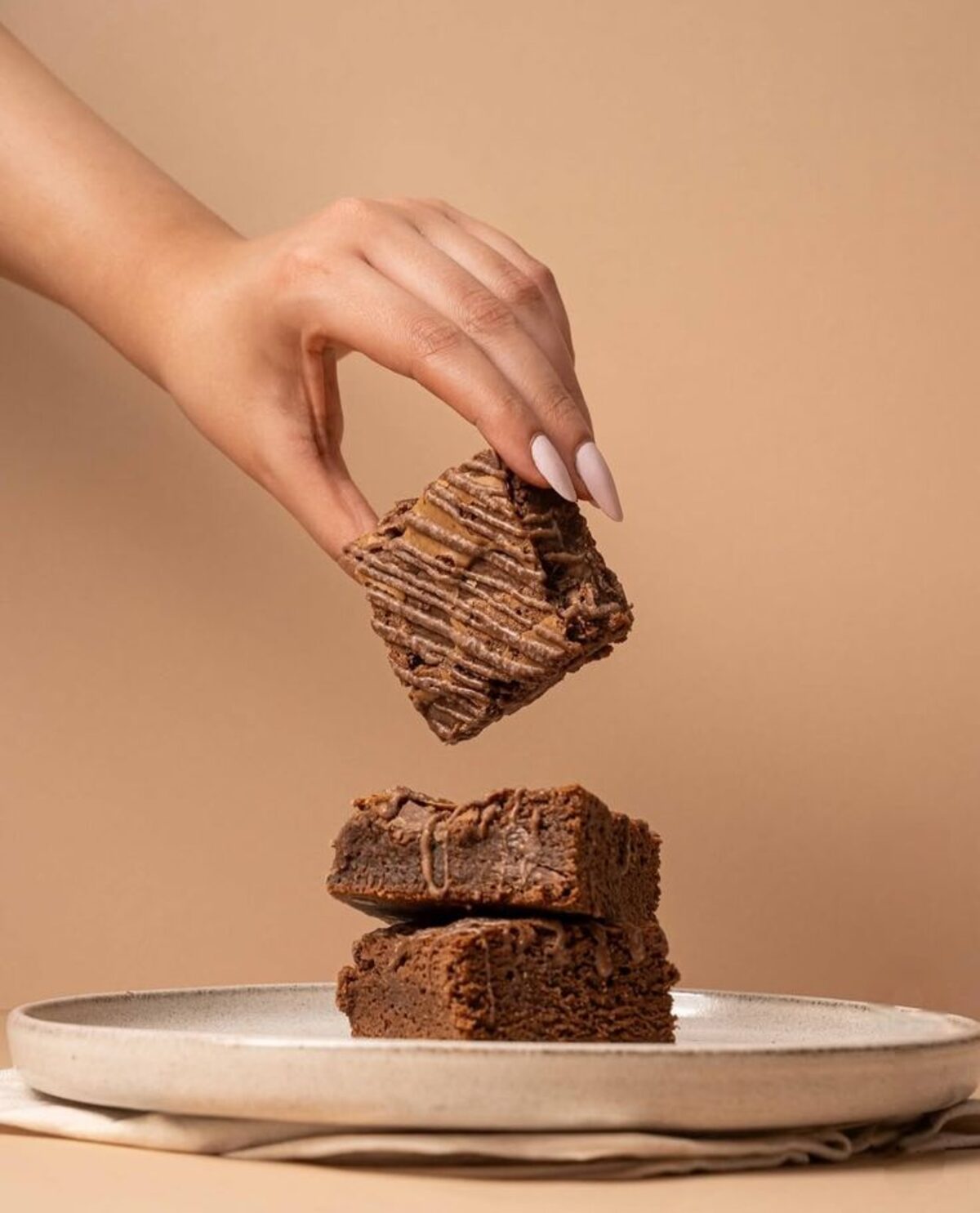 Mão pegando um pedaço de brownie